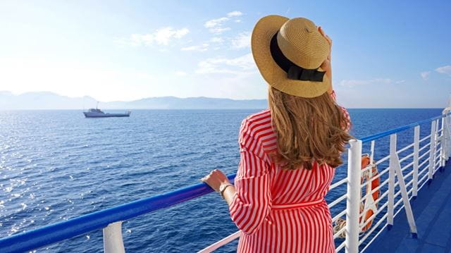 Woman admiring the view from a cruise ship